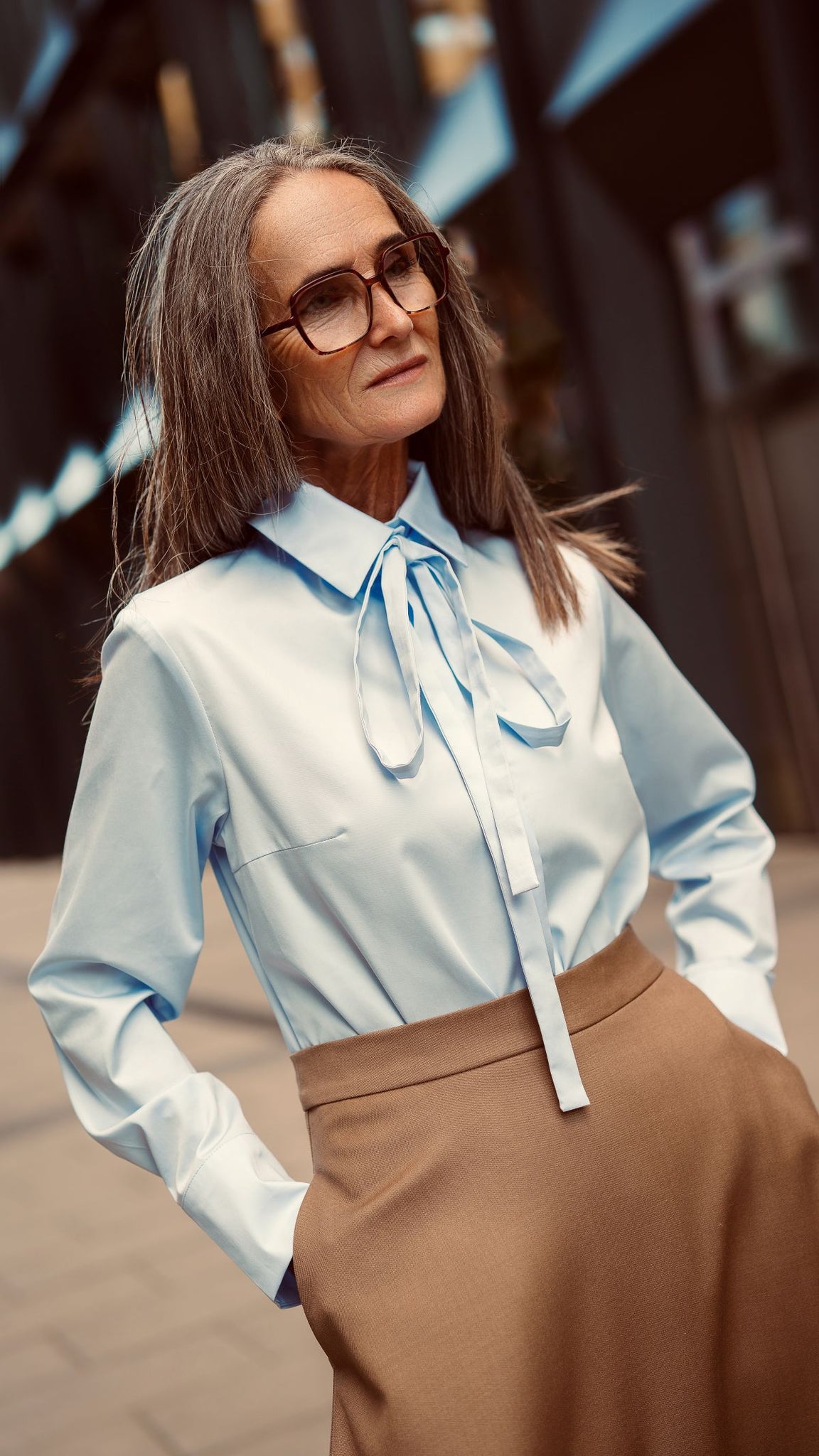 Modelka przodem zbliżenie na błękitną koszulę damską z wstążką