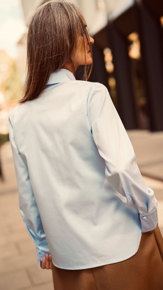 Modelka tyłem zbliżenie na błękitną koszulę damską z wstążką