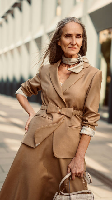 Modelka w wełnianej marynarce damskiej i apaszce stoi przodem zaqanna